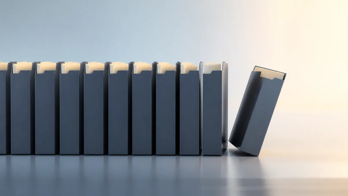 One plain project folder tipping away from a long orderly row